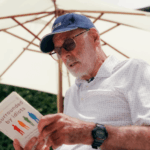 Mayor of Auckland Wayne Brown reading a book Surrounded by Idiots